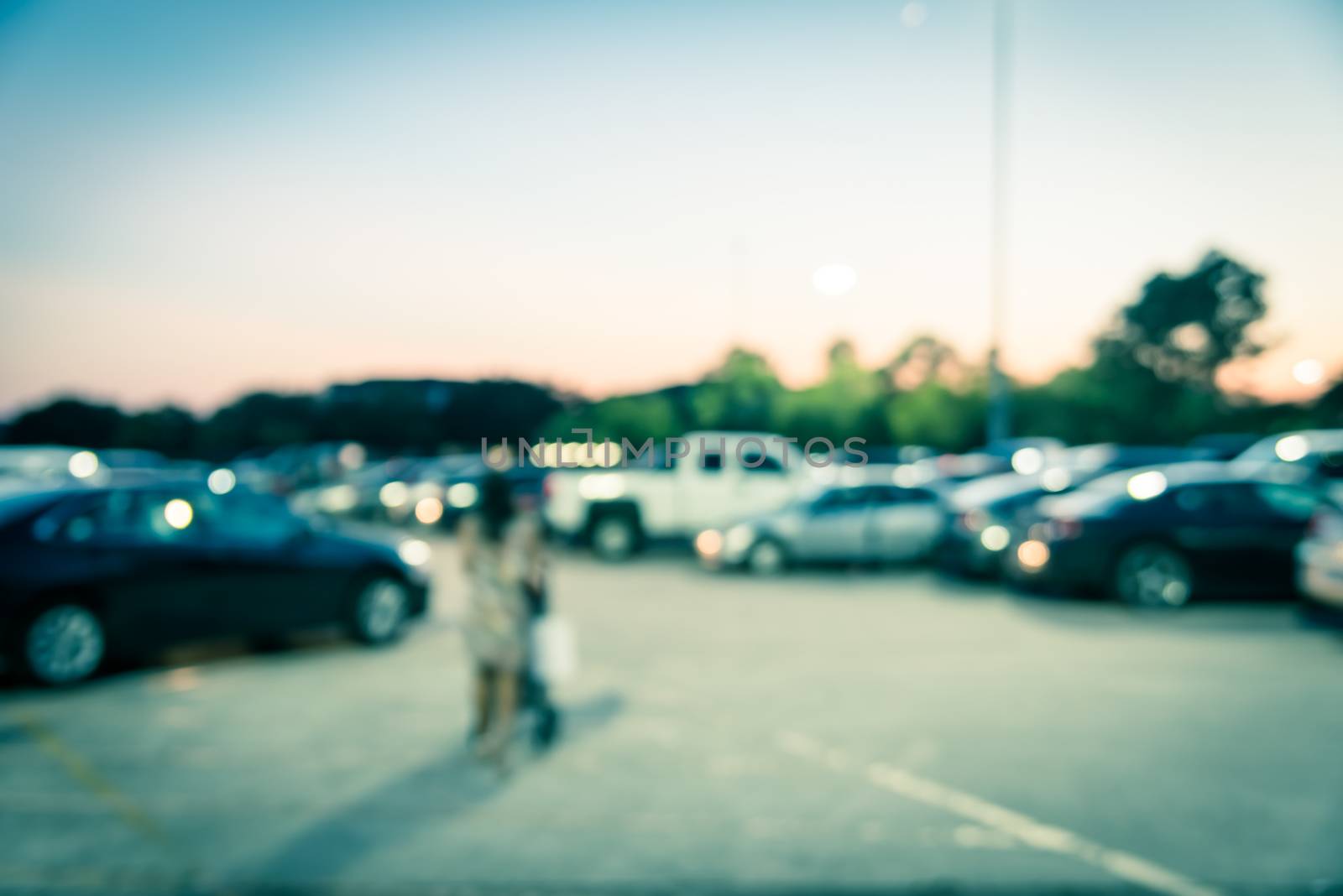 Blurry background customer walking by outdoor parking lots of shopping mall in Houston by trongnguyen