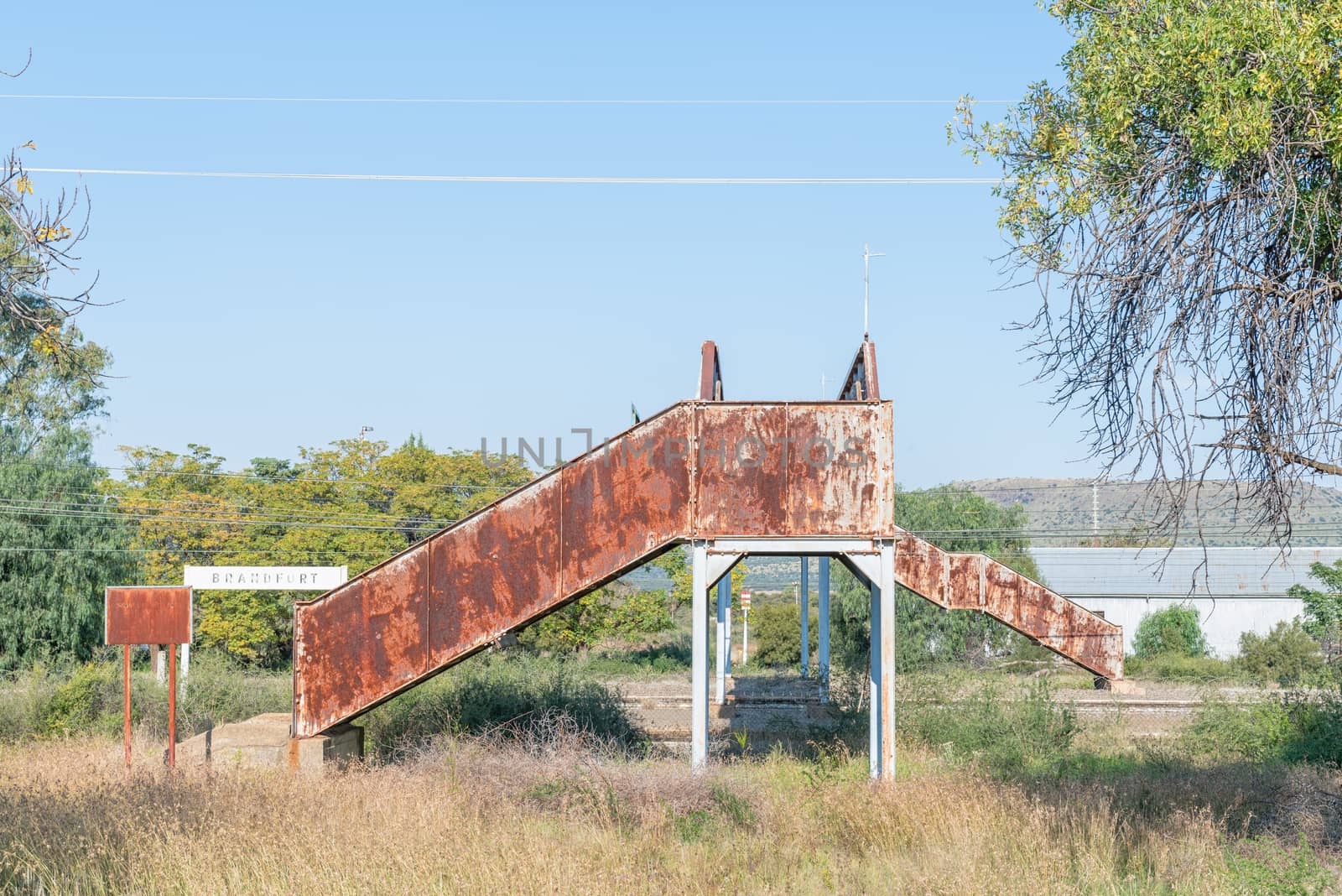 A street scene, with a rusted, old pedestrian railway bridge, in Brandfort in the Free State Province