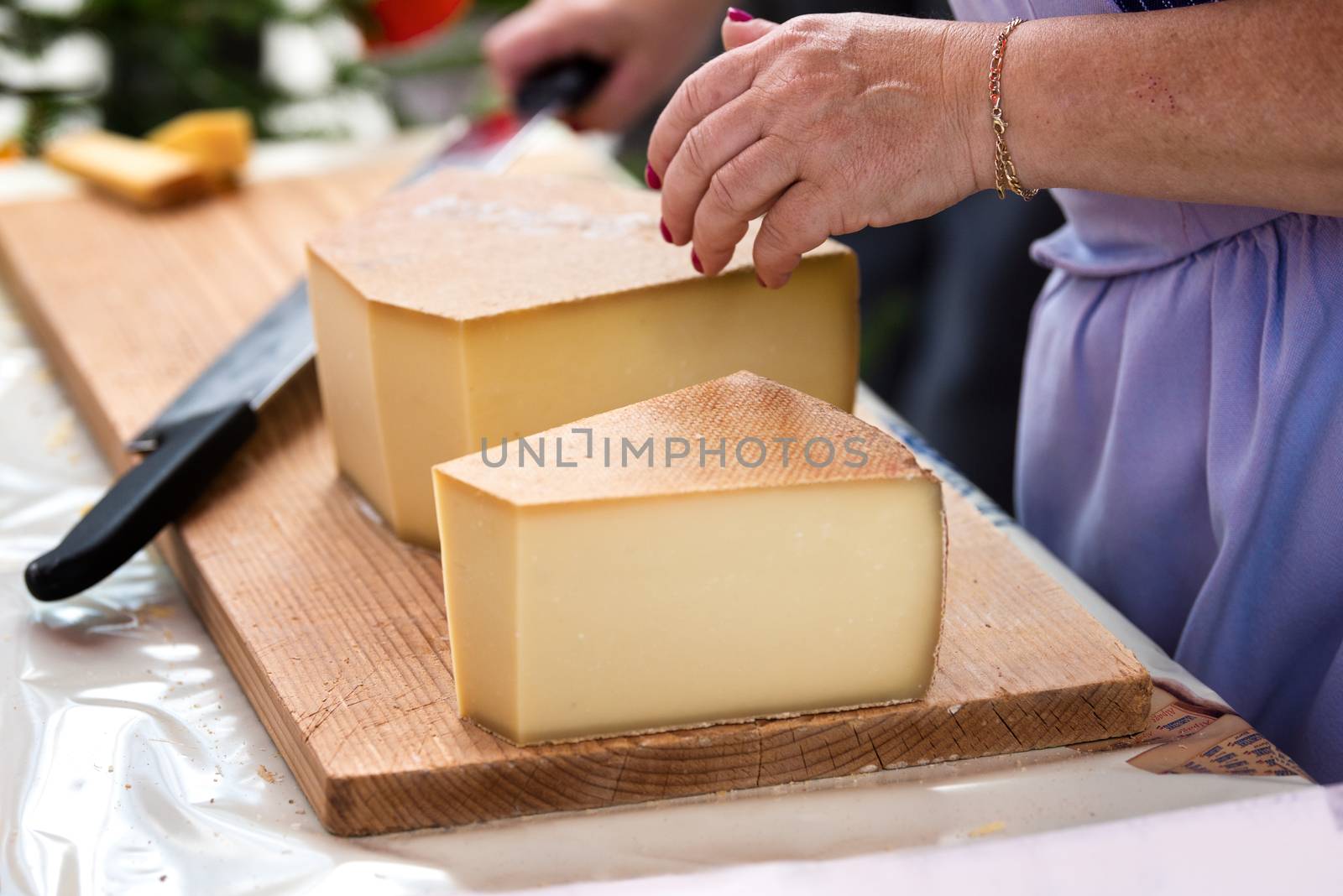 woman is saling swiss gruyere cheese in the market of Charmey, Fribourg, switzerland