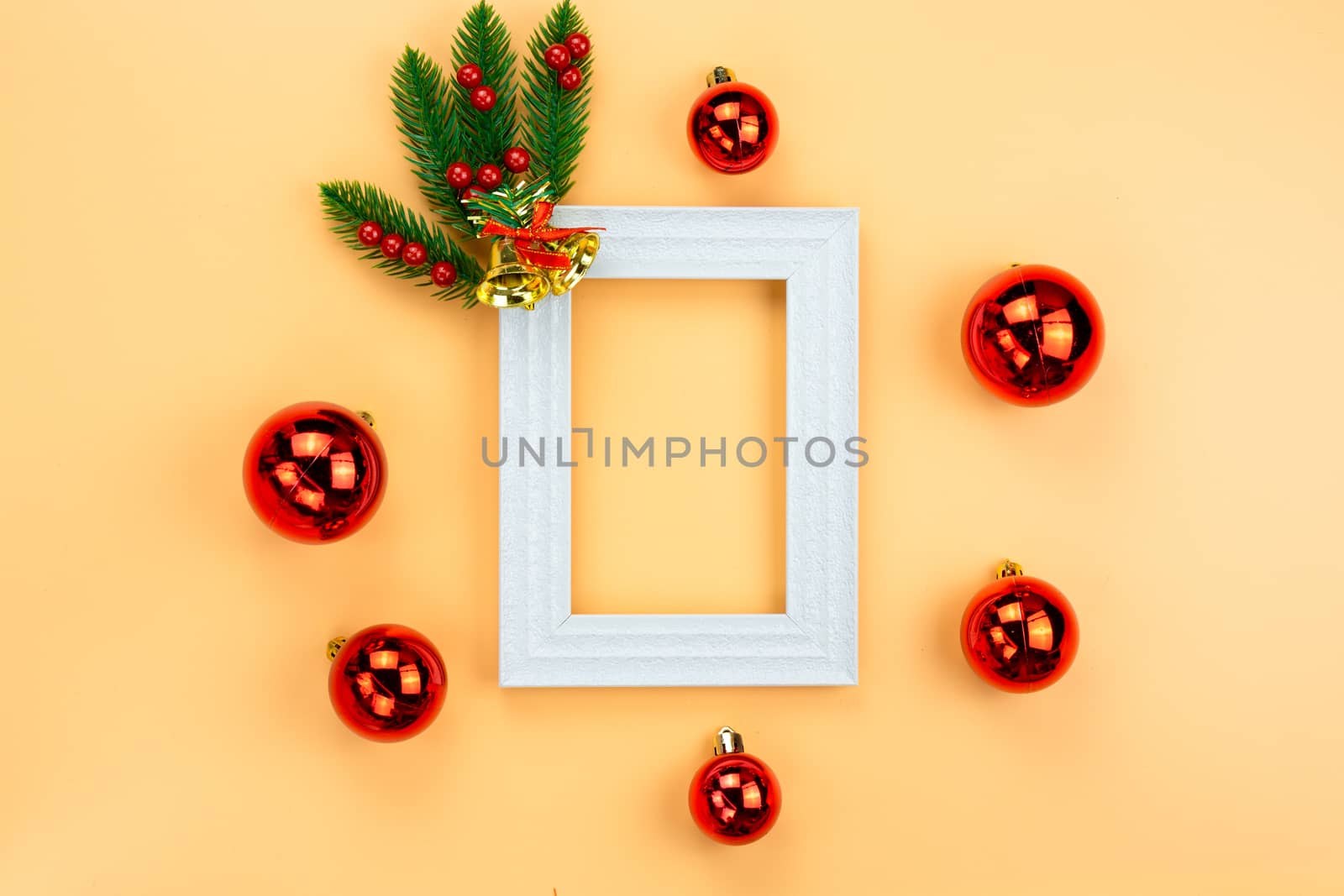 Christmas holidays composition, top view of red Christmas decorations and picture frame on yellow background with copy space for text. Flat lay, winter, postcard template, new year concept.
