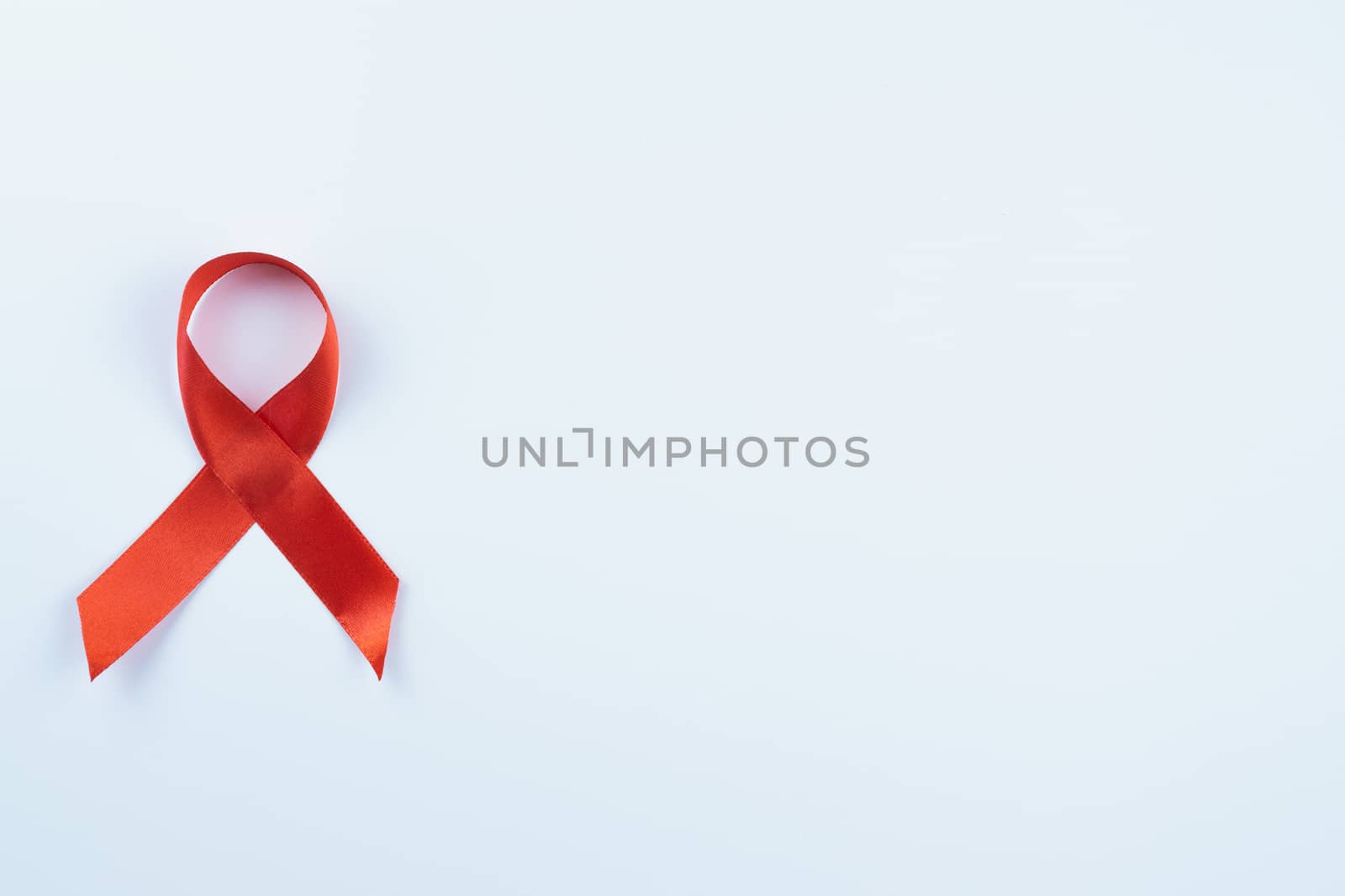 Aids awareness, red ribbon on white background with copy space for text. World Aids Day, Healthcare and medical concept.