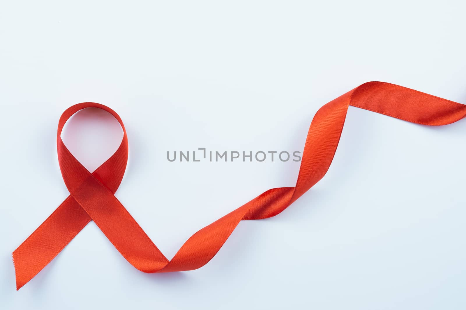 Aids awareness, red ribbon on white background with copy space for text. World Aids Day, Healthcare and medical concept.