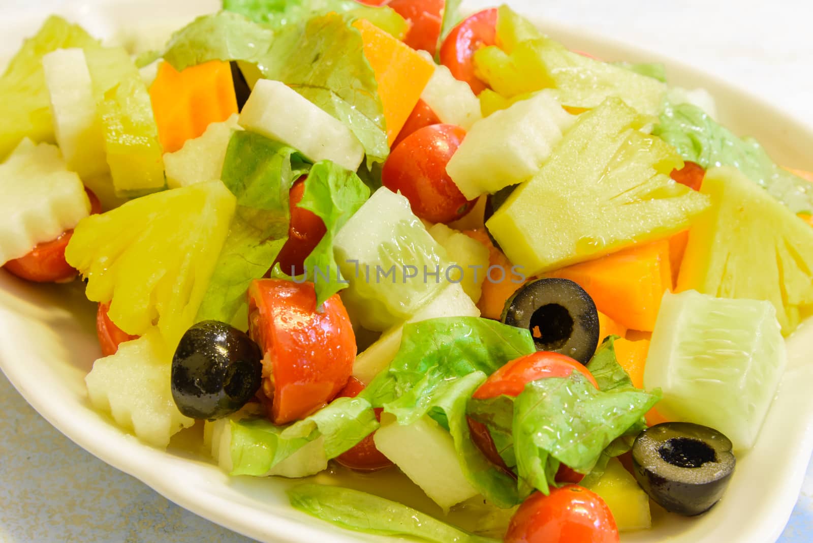 Close-up a fresh dish of mixed organic fruits salad healthy side food by trongnguyen