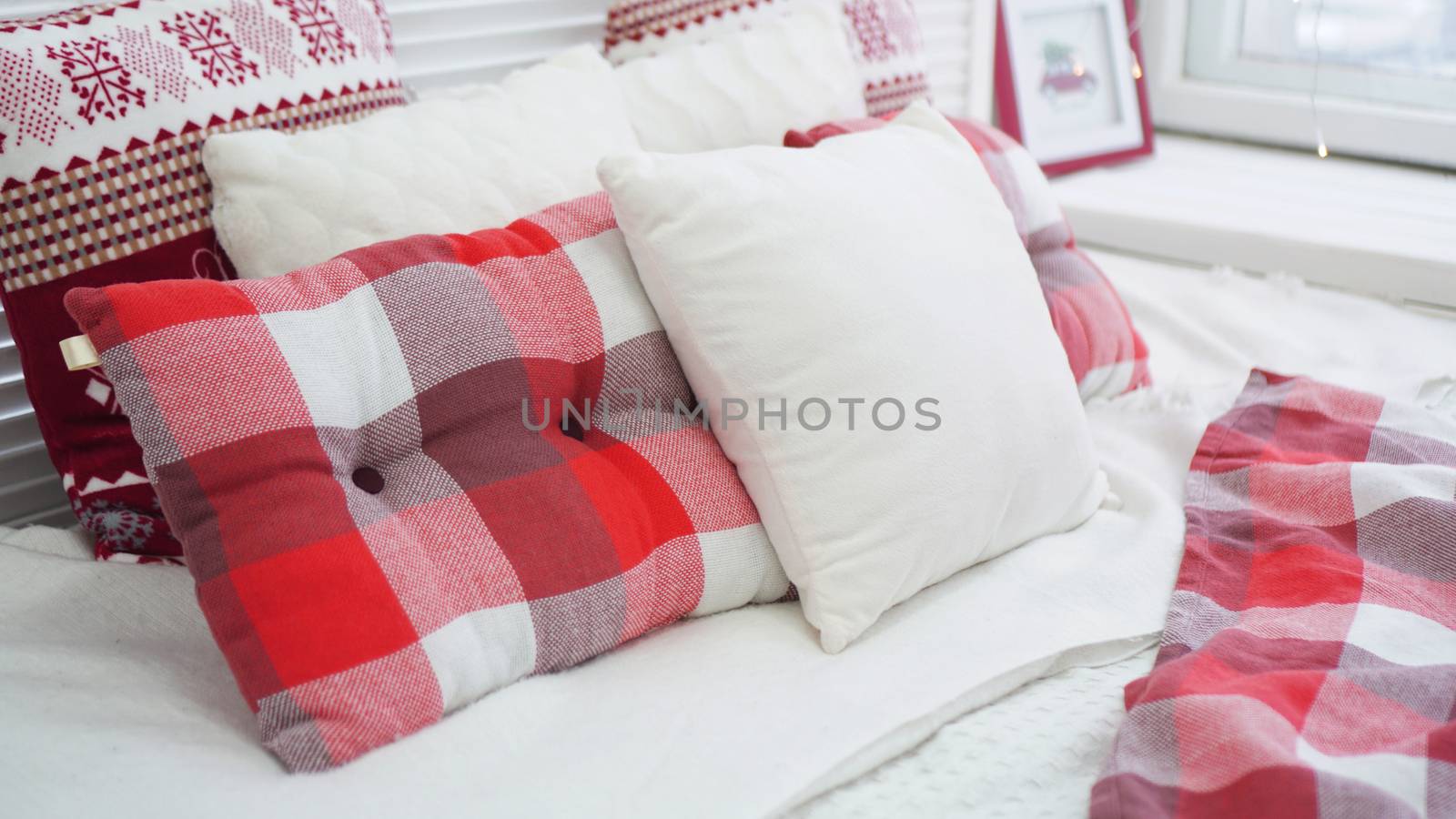 Winter Christmas decorations. Red White pillows on the bed.