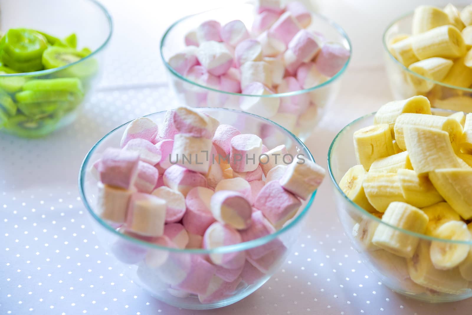 Sweet marshmallow with bananas in glasses bowl. Selective focus