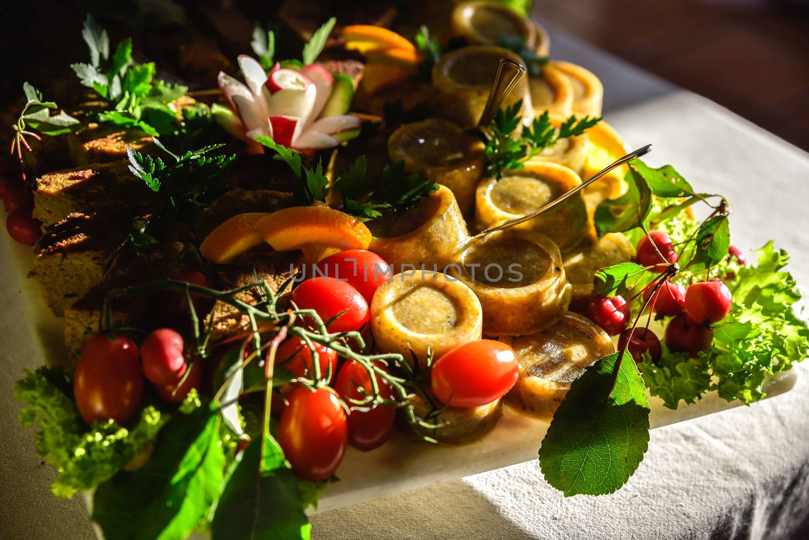 A widely varied food with coctail sticks on wooden plate, harsh sun light.