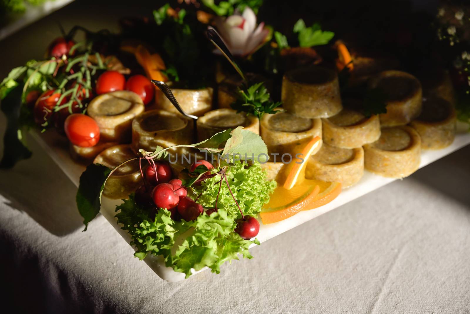 A widely varied food with coctail sticks on wooden plate, harsh sun light.