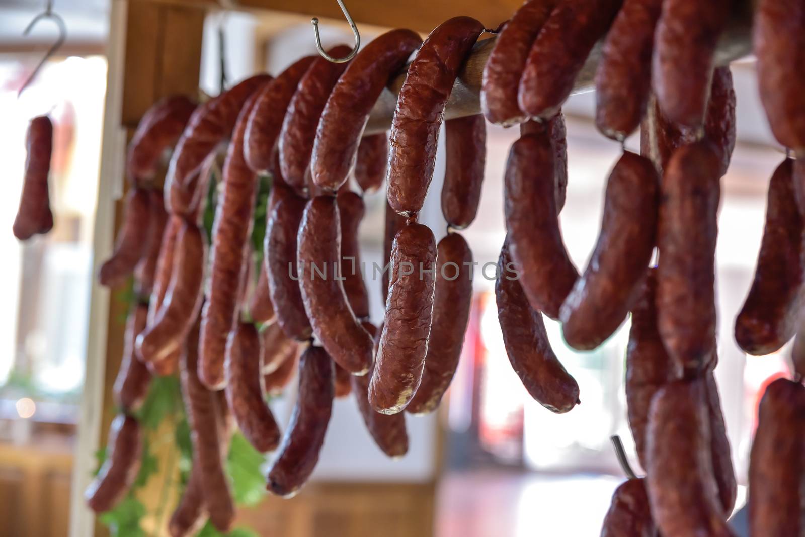 Country table with many kinds of ham and sausage hanging down