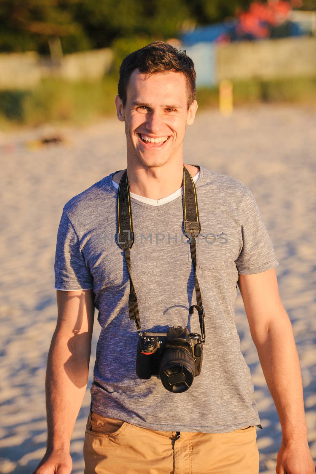 Silhouette of young photographer on the beach. Summer time
