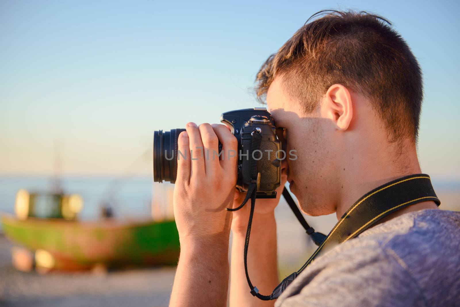 Silhouette of young photographer on the beach. Summer time
