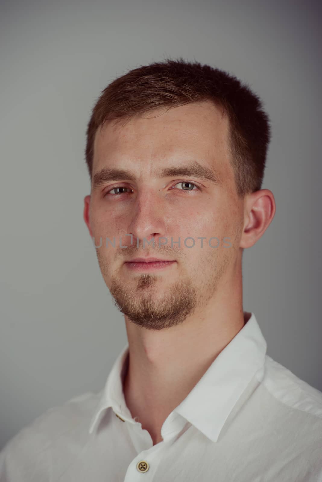 Portrait of a smiling young brunette man in studio