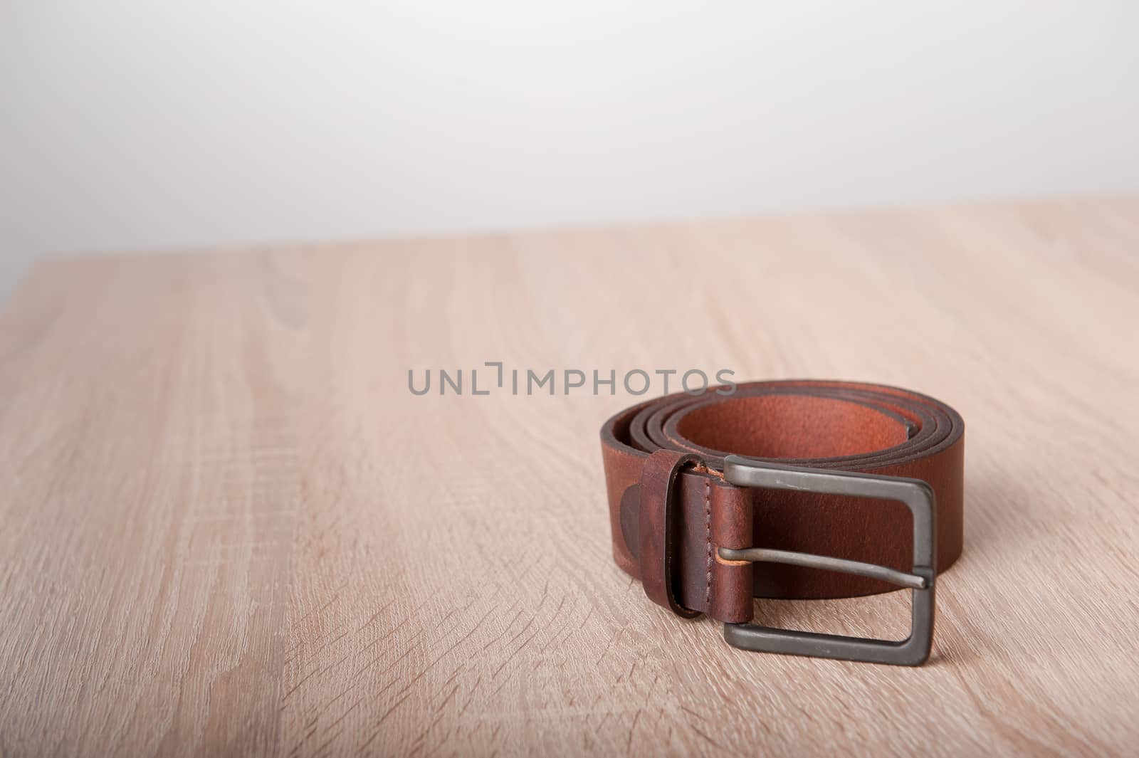 Leather belt on the wooden desk table
