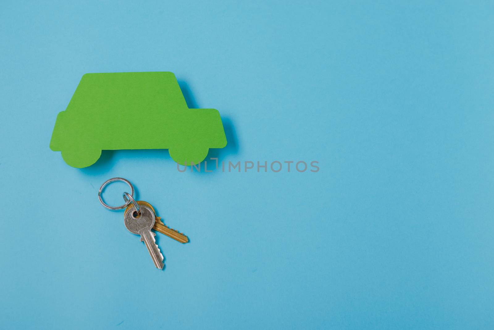 paper green cars figure with keys. top view on blue background