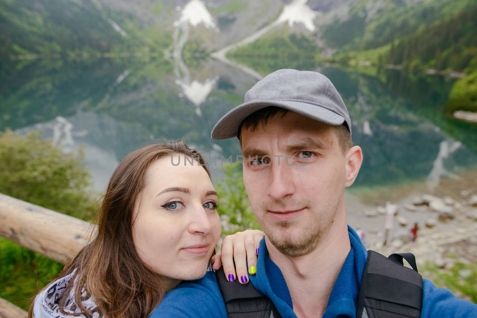Happpy couple taking selfie withe lake background in the mountains