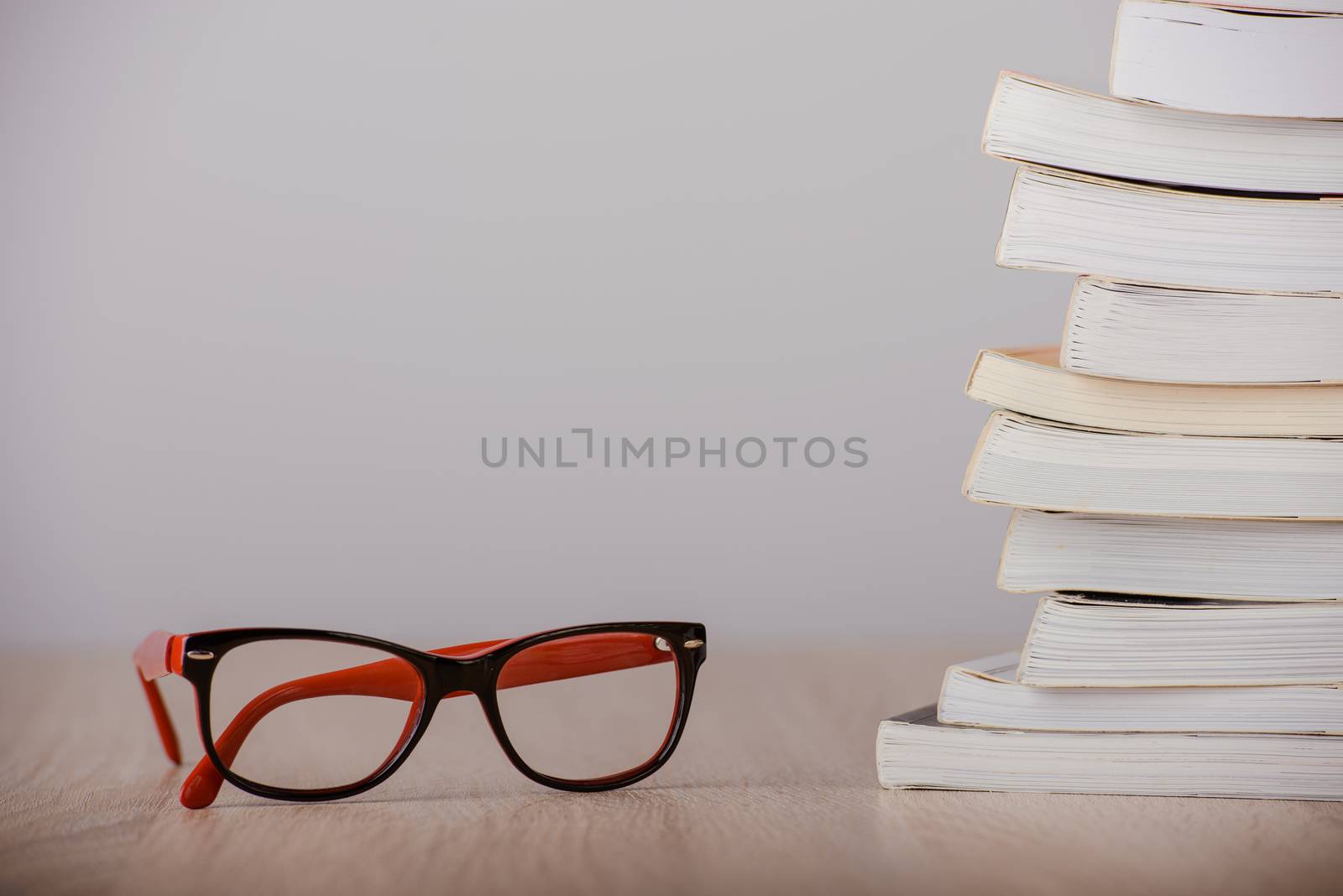 book and eyeglasses on wood background desk