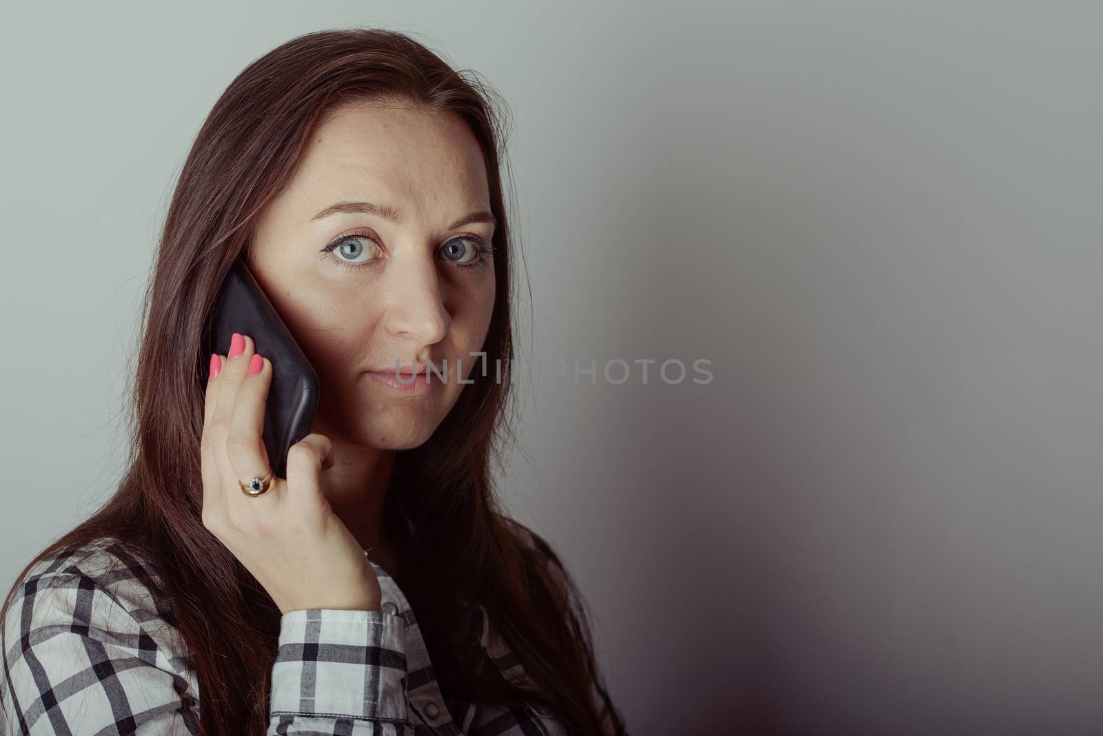 Happy brunette girl talking via smartphone at home