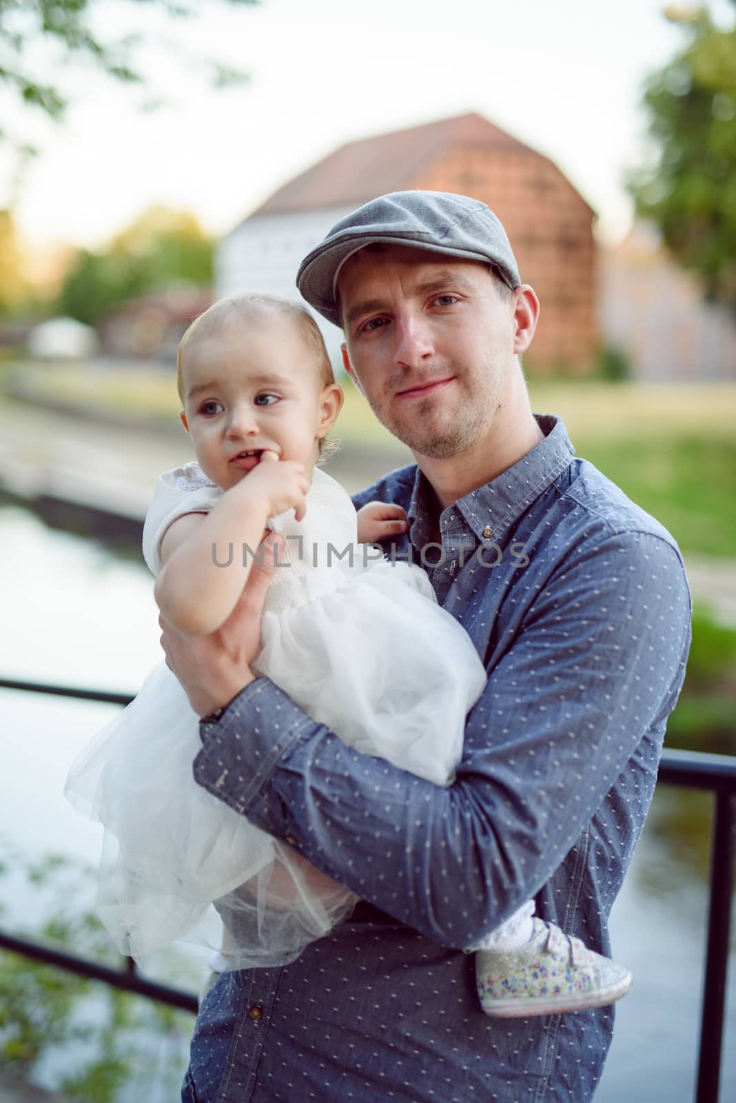 Happy loving family. Father and his daughter child girl playing and hugging outdoors. Cute little girl hugs daddy. Concept of Father's day. Authentic image.