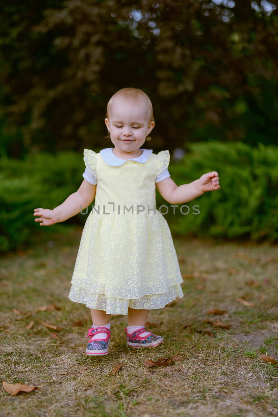 Smiling girl on the meadow looking right at camera. authentic image. Smell roses flowers
