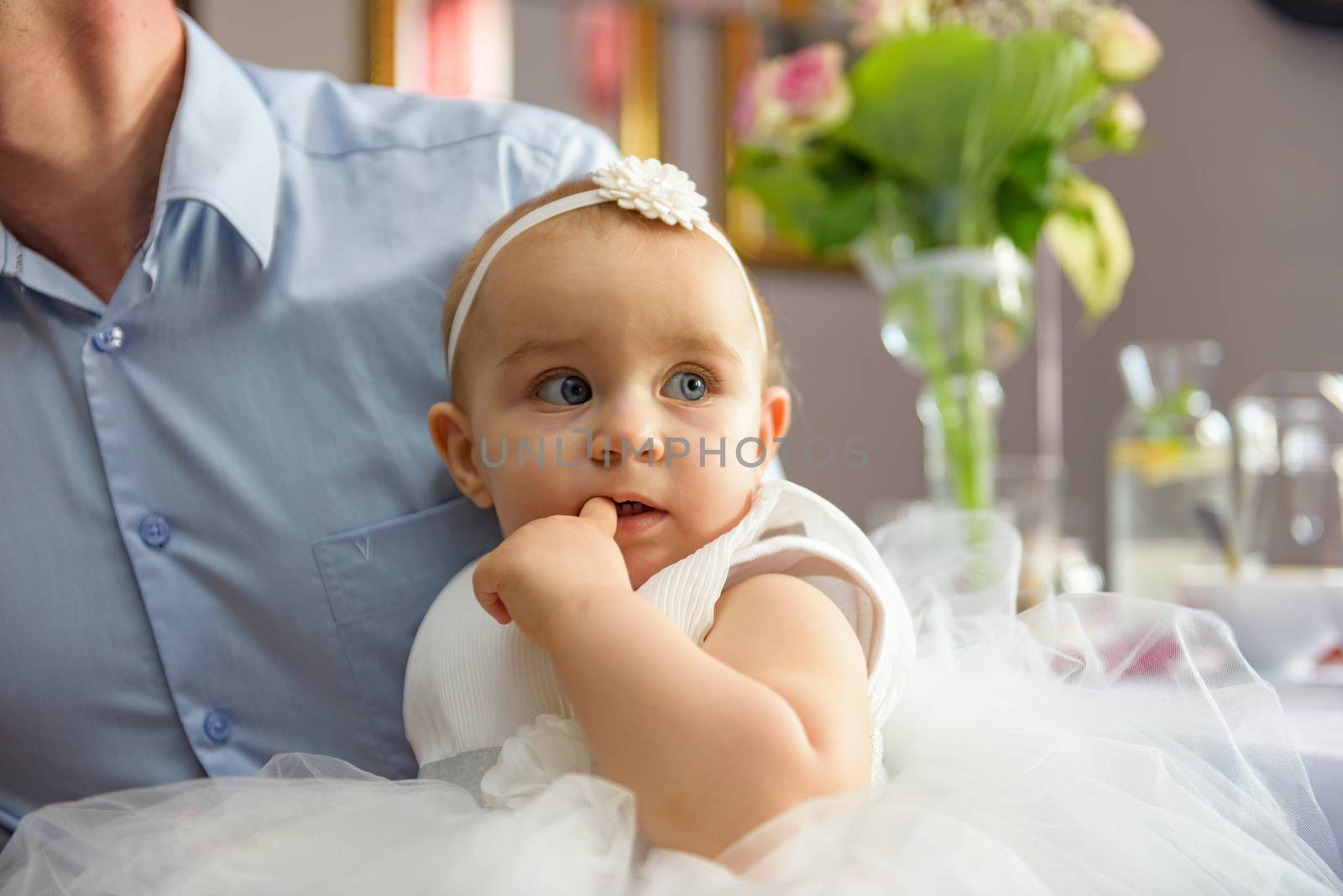 Baby girl 1 year old eating birthday cake in room. Birthday party. Childhood.
