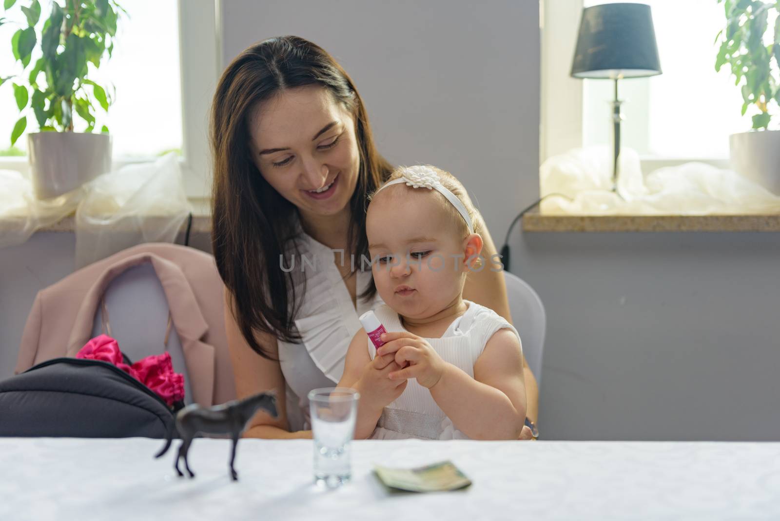 Baby girl 1 year old eating birthday cake in room. Birthday party. Childhood.