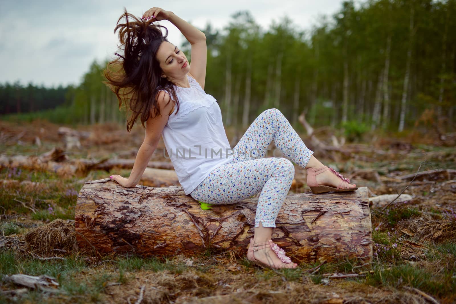 a photo of woman in the forest where the purple heather blooms. copy space. authentic image