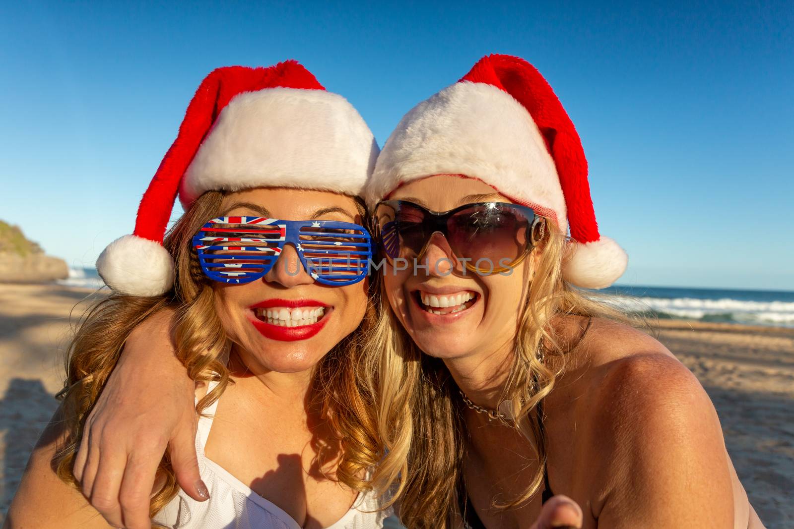 Happy women on the beach having fun Christmas party by lovleah