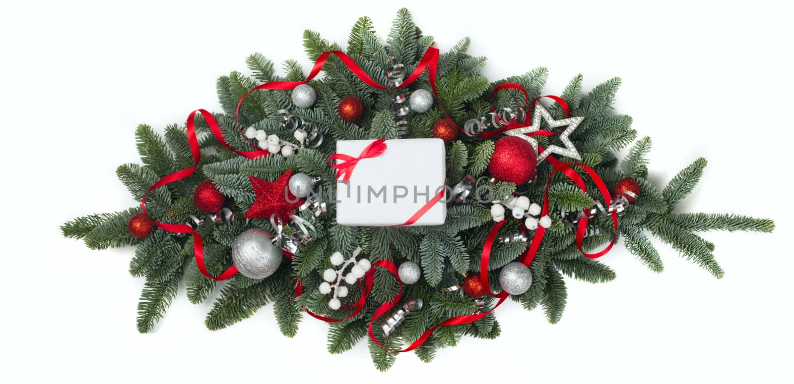 Christmas design element of noble fir tree branches and red baubles isolated on white background