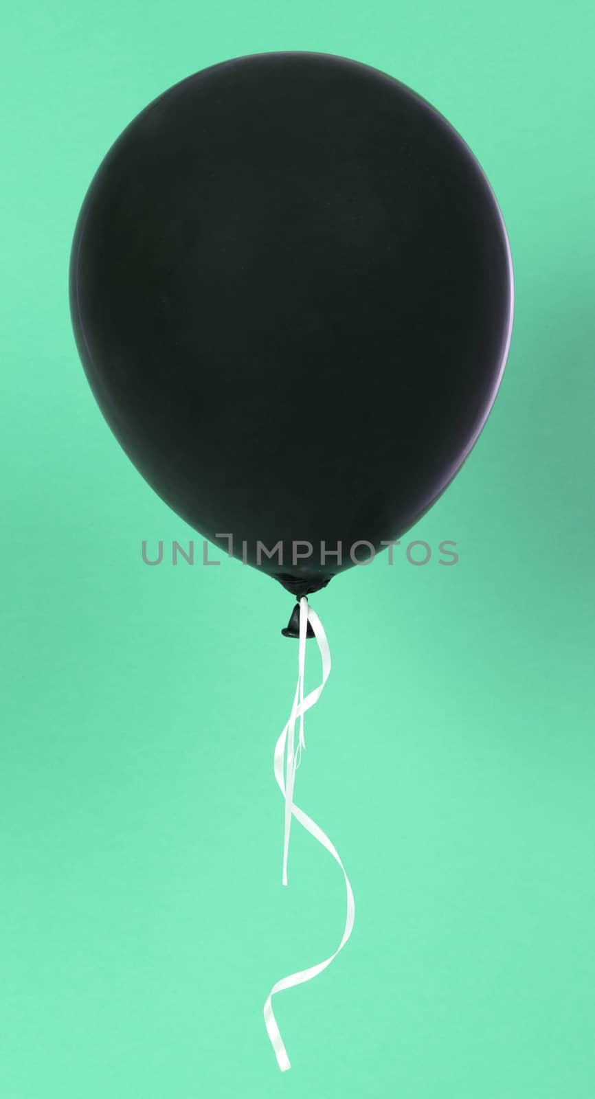 Black balloon isolated on a green background