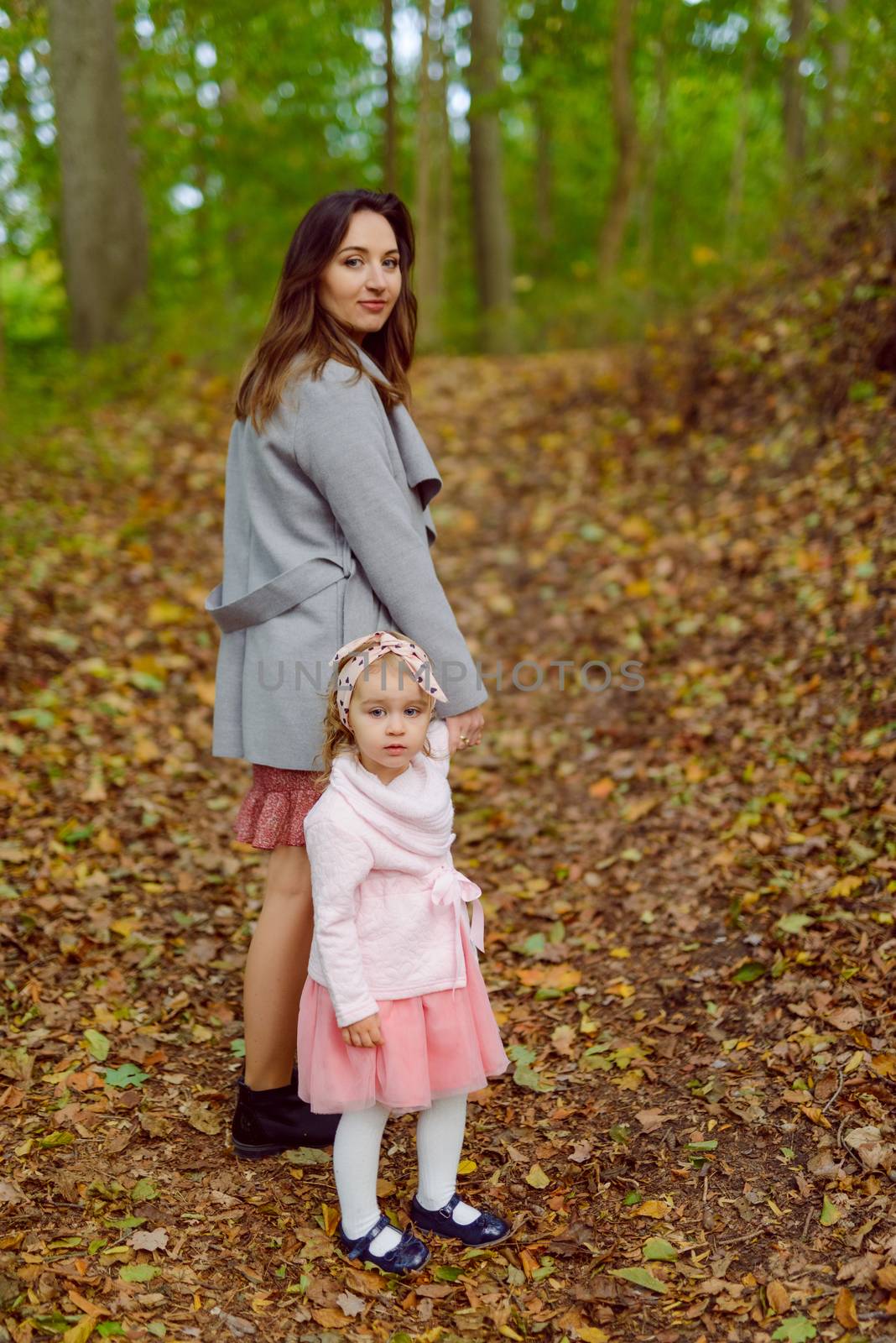 Beautiful little girl on a walk in the park on a sunny day. Autumn day