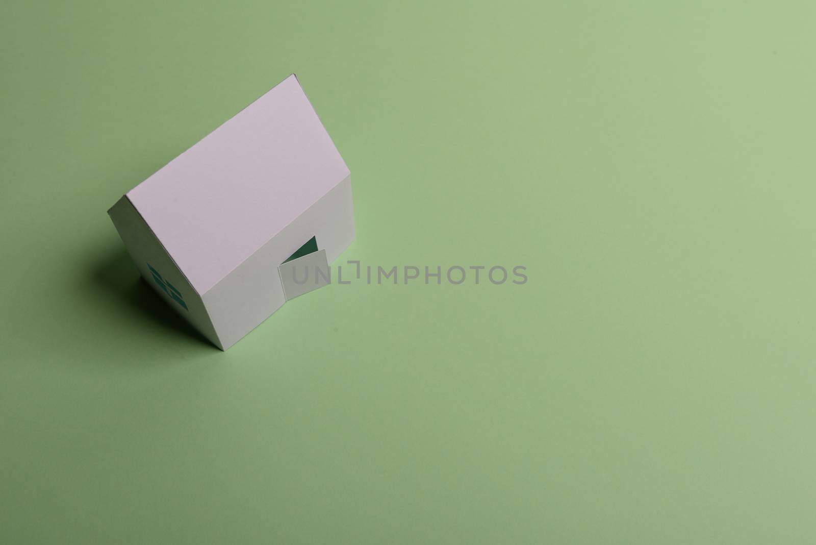 White family paper house , stack of money coins, house projects plan and blueprints on mint background paper. Minimalistic and simple concept, style. Vertical orientation