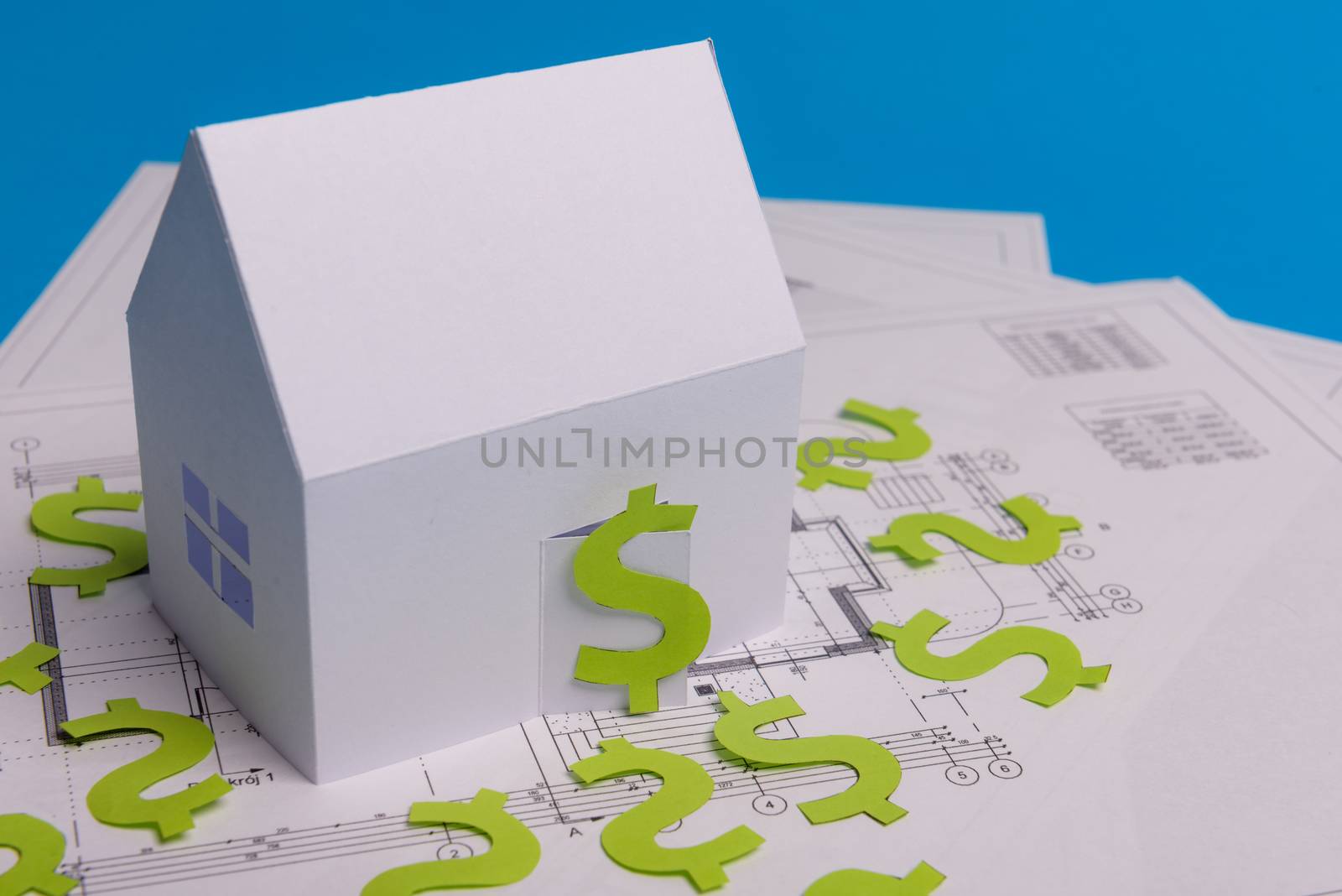 Paper skyscrapers , us dollar money, house projects plan and blueprints on blue background paper. Minimalistic and simple concept, style. Horizontal orientation. View from above. Copy space.