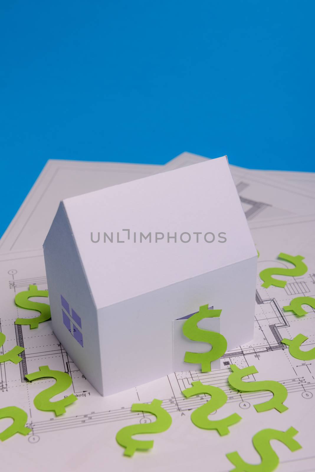 Paper skyscrapers , us dollar money, house projects plan and blueprints on blue background paper. Minimalistic and simple concept, style. Horizontal orientation. View from above. Copy space.