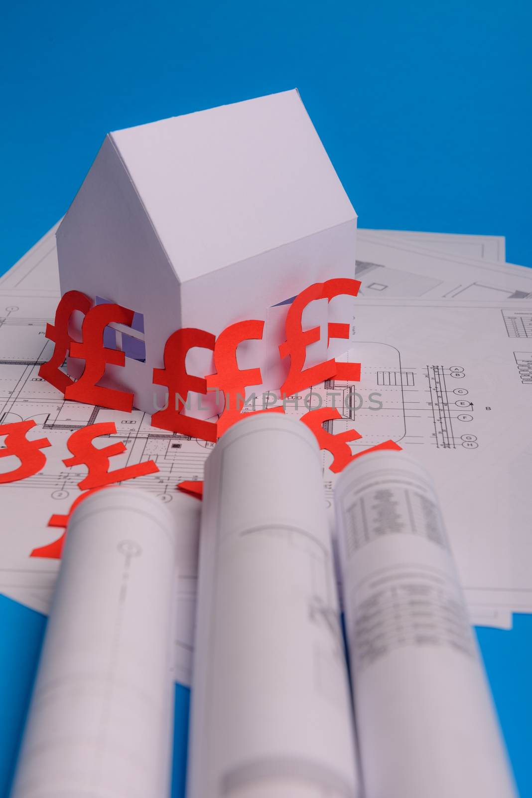 White family paper house , british pound money symbol , house projects plan and blueprints on mint background paper. Minimalistic and simple concept, style. Vertical orientation. View from above. copy space
