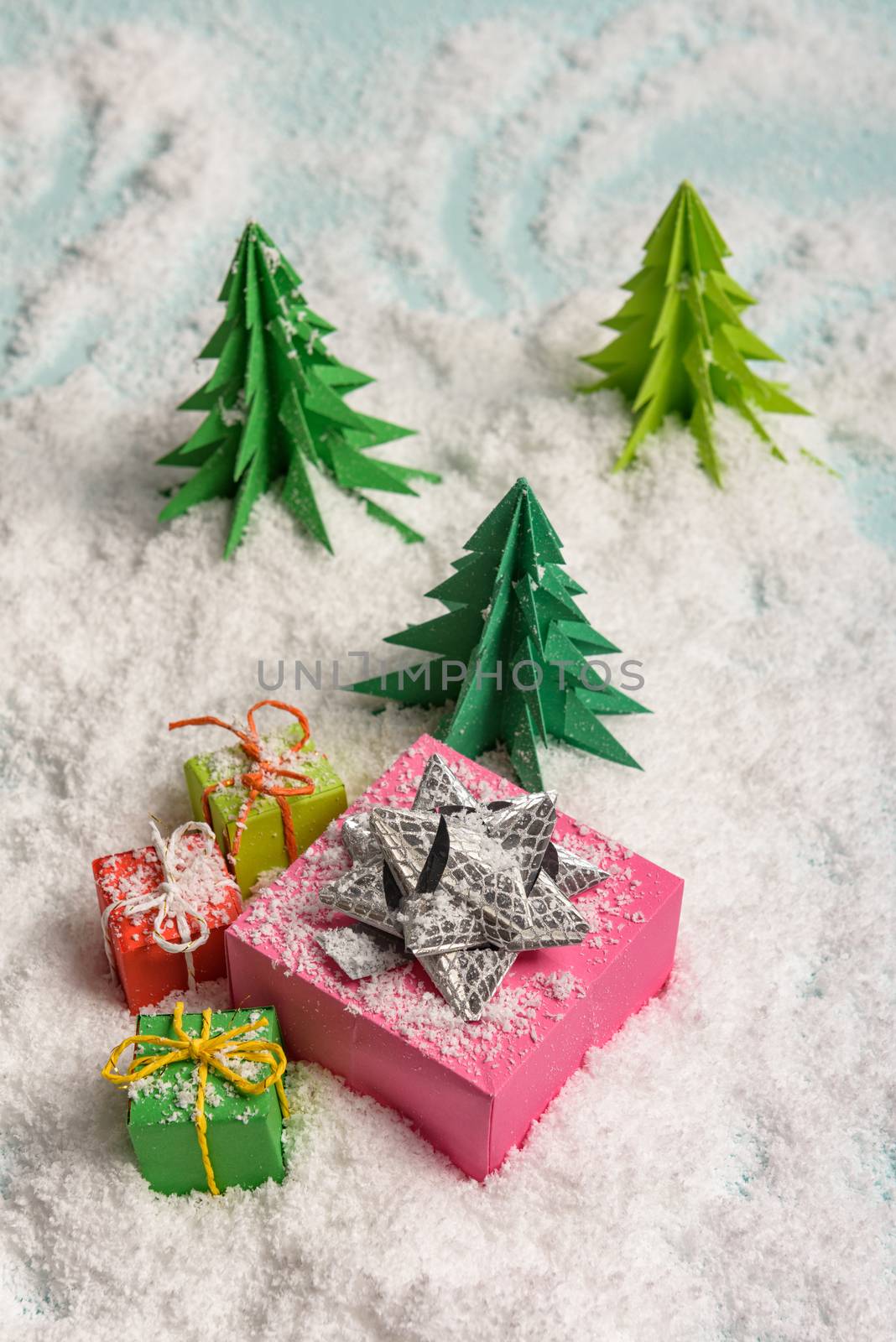 christmas presents nicely decorated with bows and feathers in snow. view from above