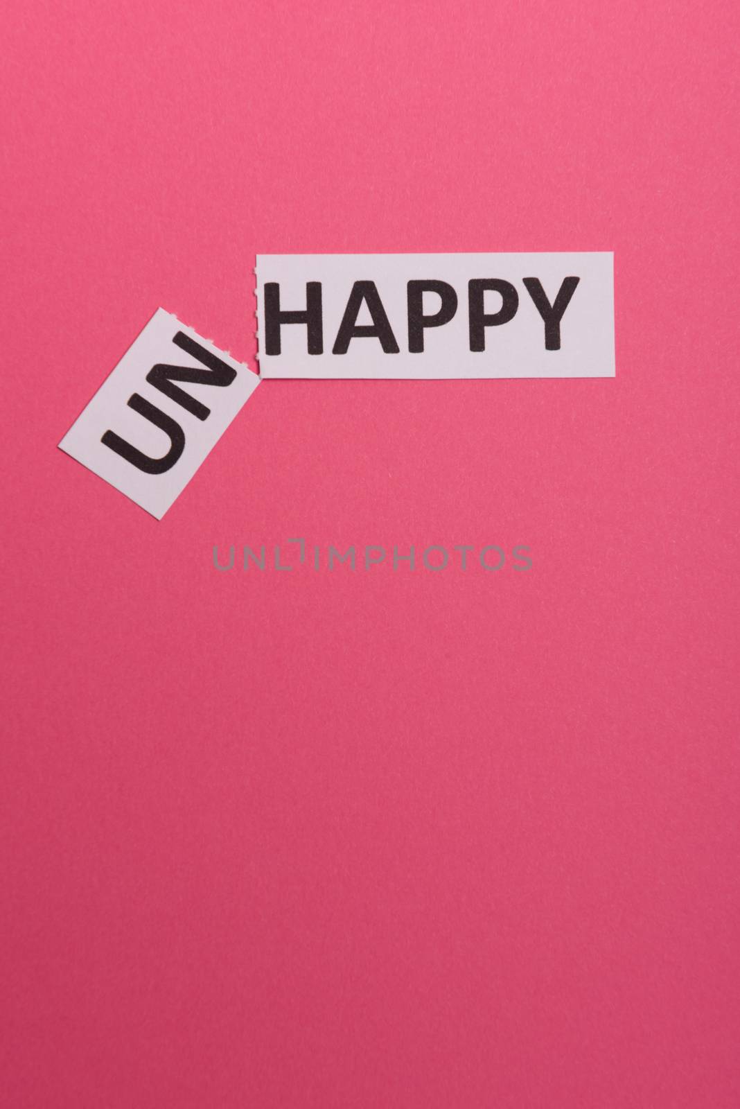 card with text unhappy, cutting word 'un' so it written 'happy'. Copy space. Lime background. Studio shoot.