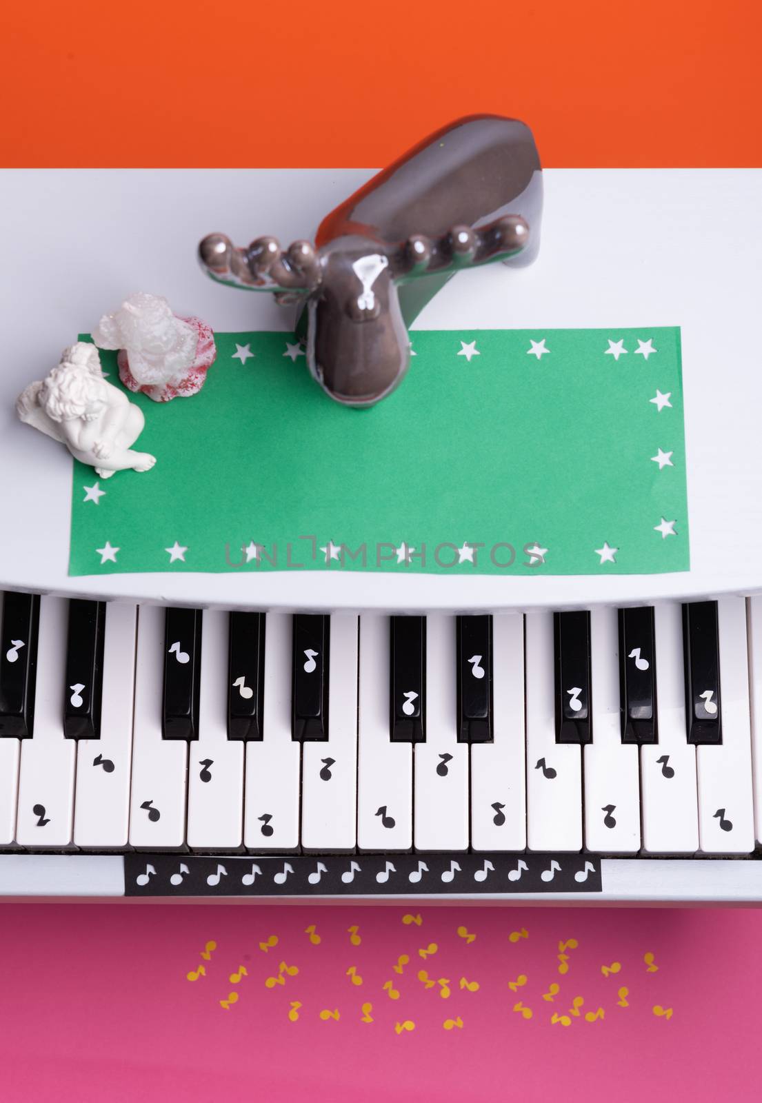 white toy piano with paper notes. music piano concept. view from above. White, black and yellow music notes.
