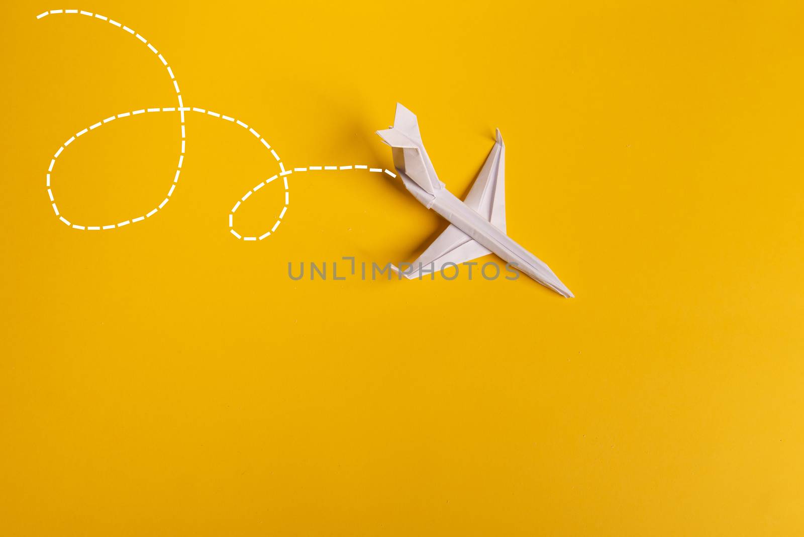 Group of paper plane in one direction and with one individual pointing in the different way on yellow background. Smoke coming out from aircraft tails