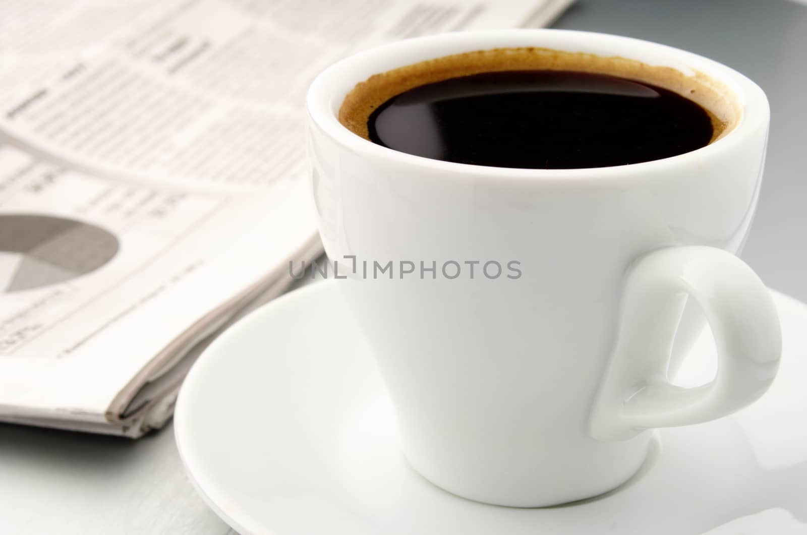white cup of coffee and newspaper on the table