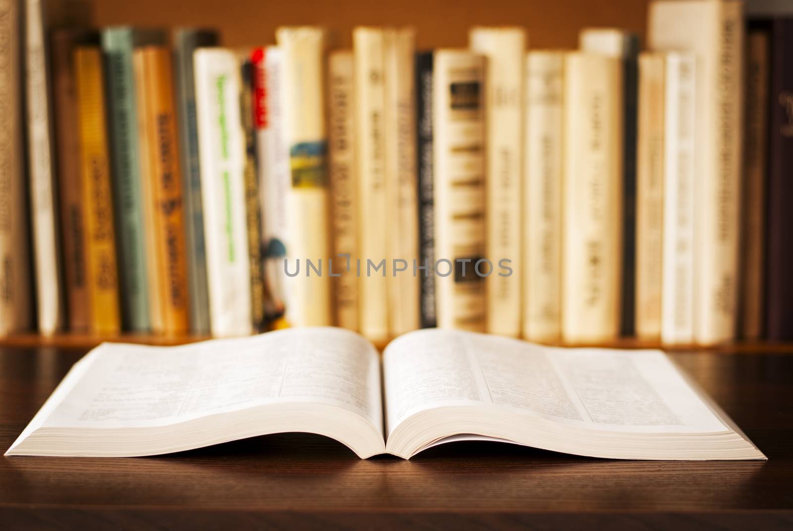 open book on the table and a bookshelf in the background