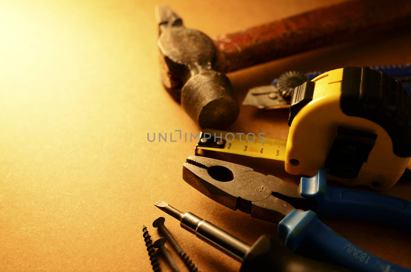 Set of home maintenance tools arranged in a semi-circle to the right of the frame with copyspace in sepia toned lighting