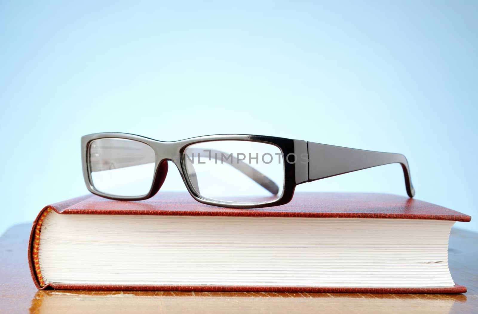 black-rimmed glasses and a book on the table