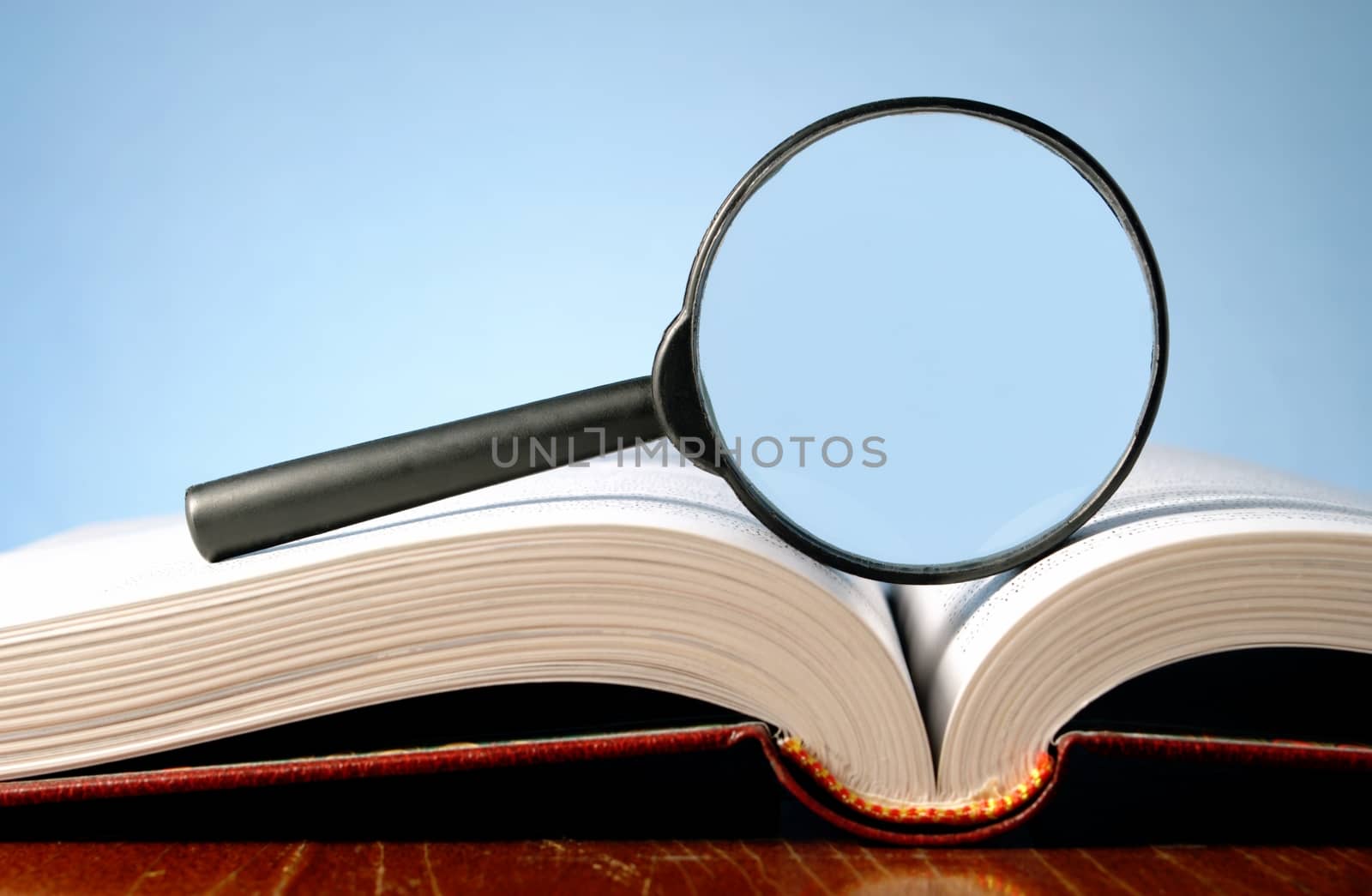 magnifying glass and an open book on a table