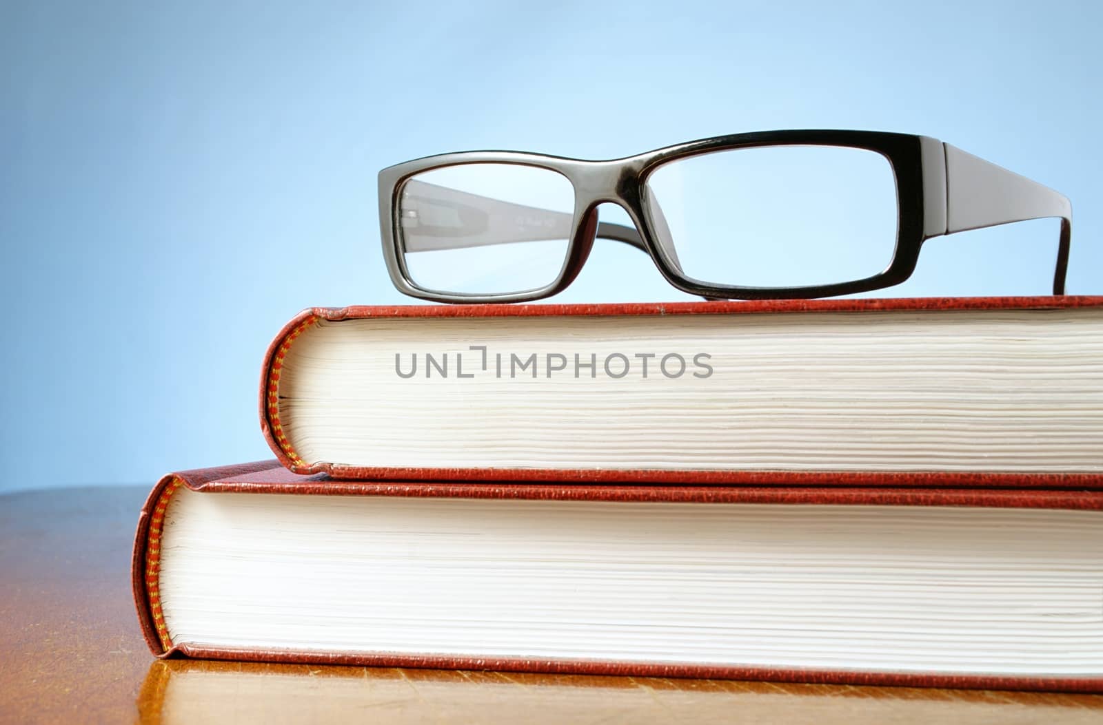 book and black-rimmed glasses on a table