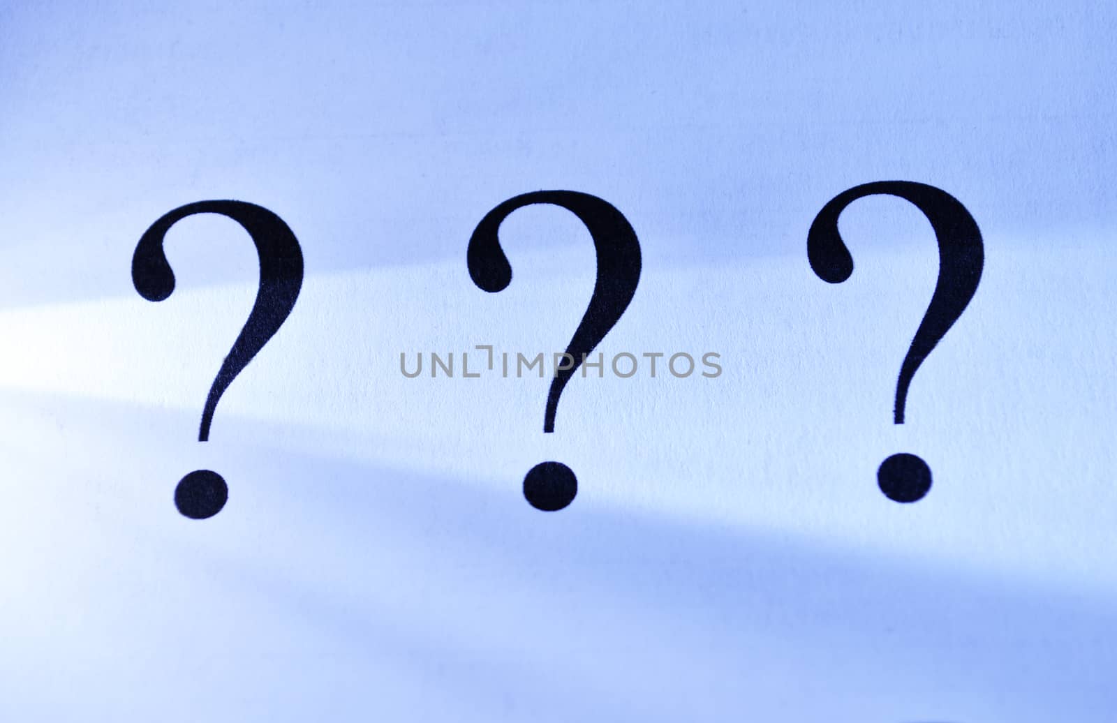 Three question marks on an abstract blue background depicting unanswered questions, interrogation, confusion and solutions