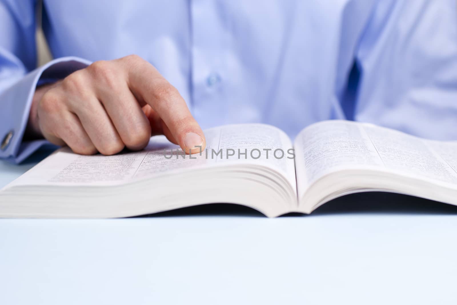 man reading a book, shows a close-up hand and a book