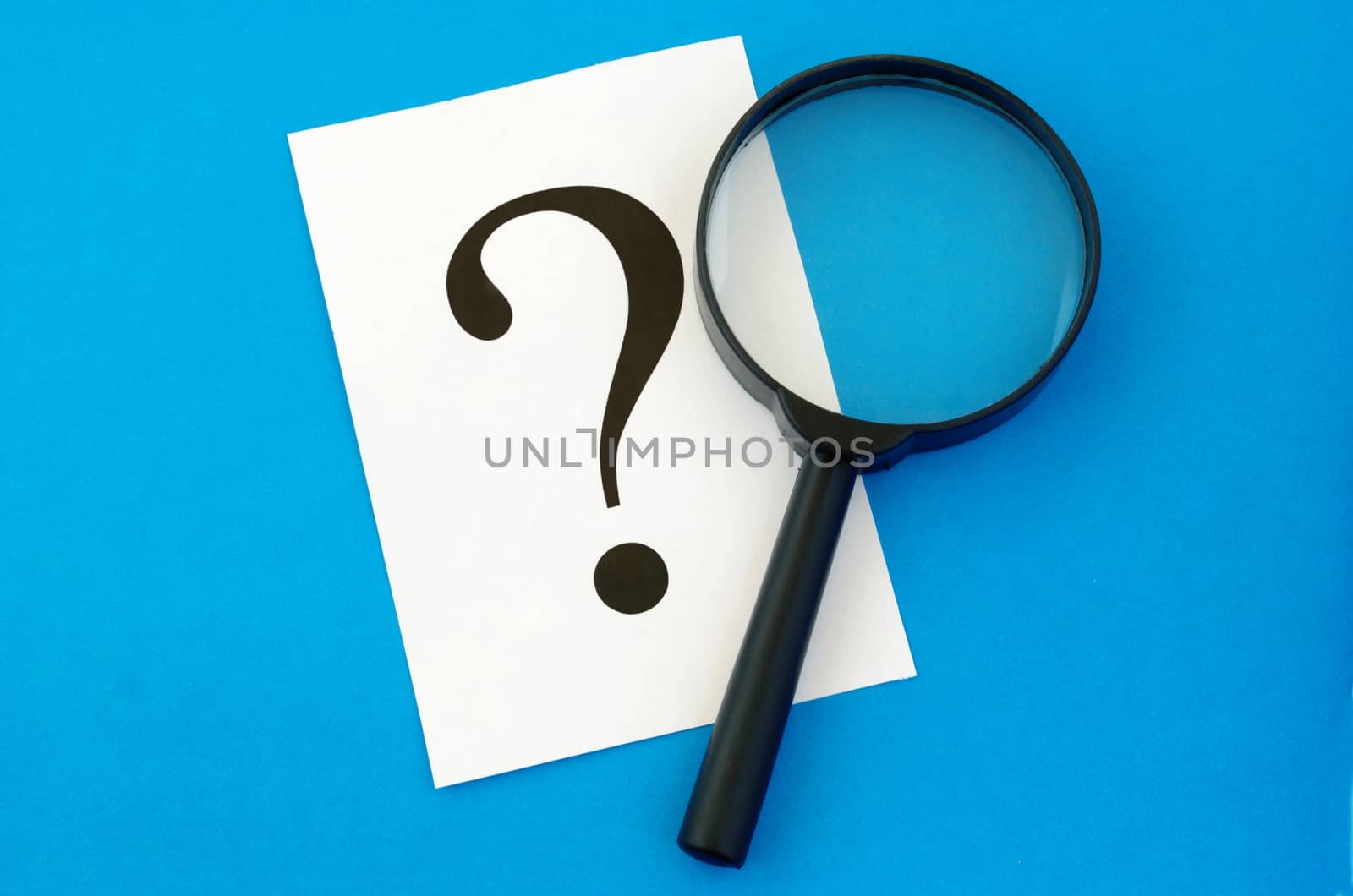 question mark on the paper and a magnifying glass
