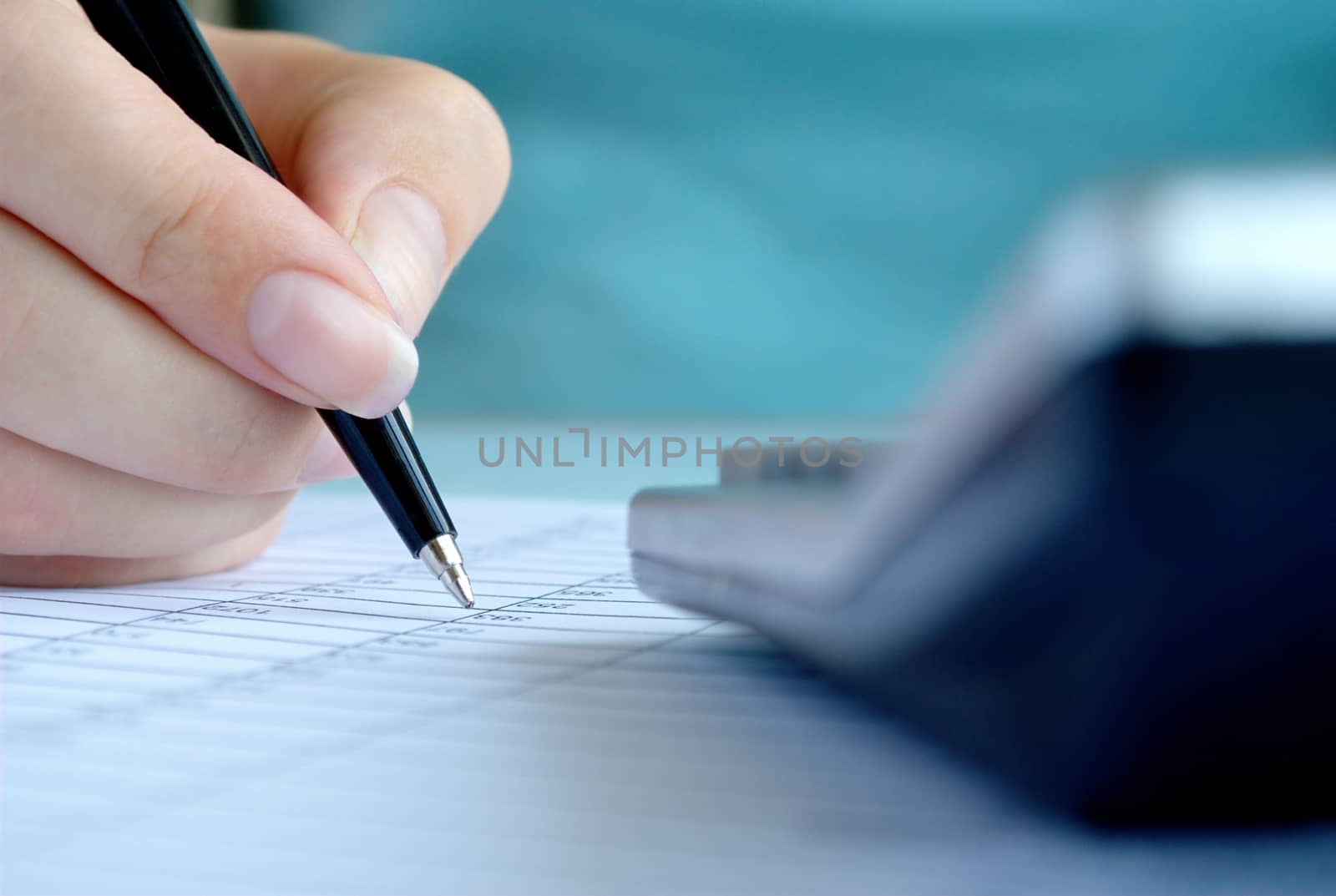 woman's hand writing entries in a notebook