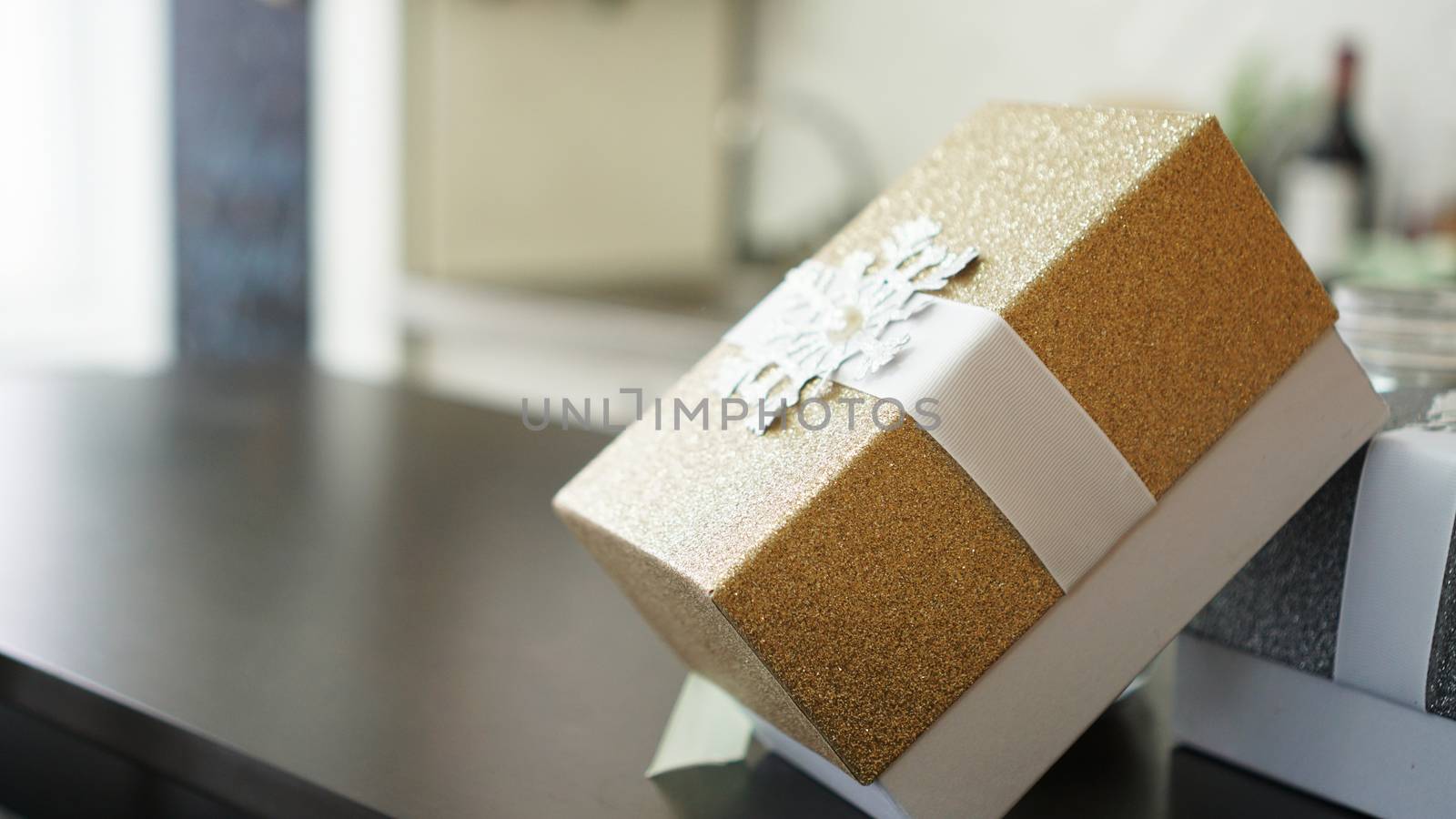 Gold present box on wood table with blurred background with place for text, Holiday concept