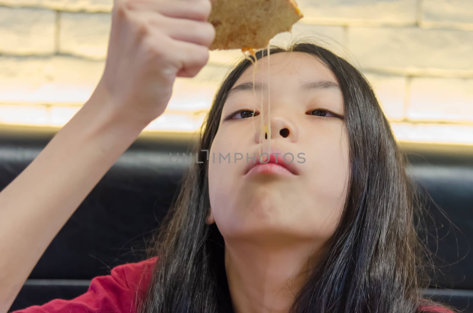 Asian Child girl with long hair eat pizza.