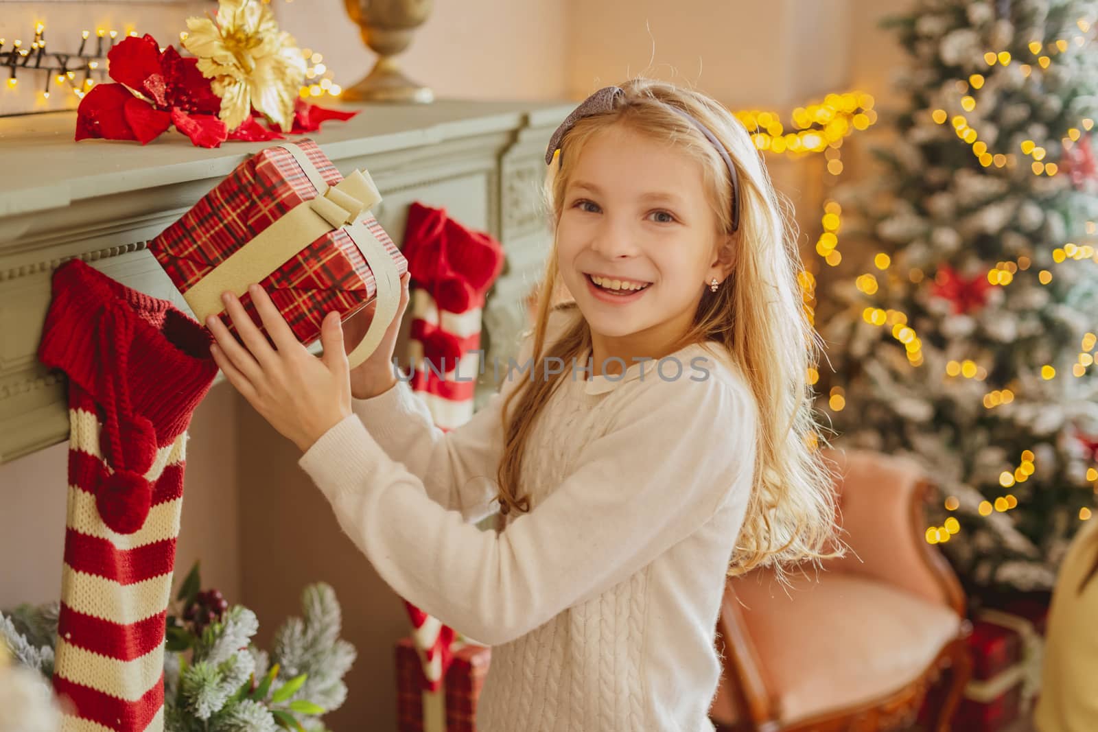 Cute teen girl with present near Christmas tree smiiling by Angel_a